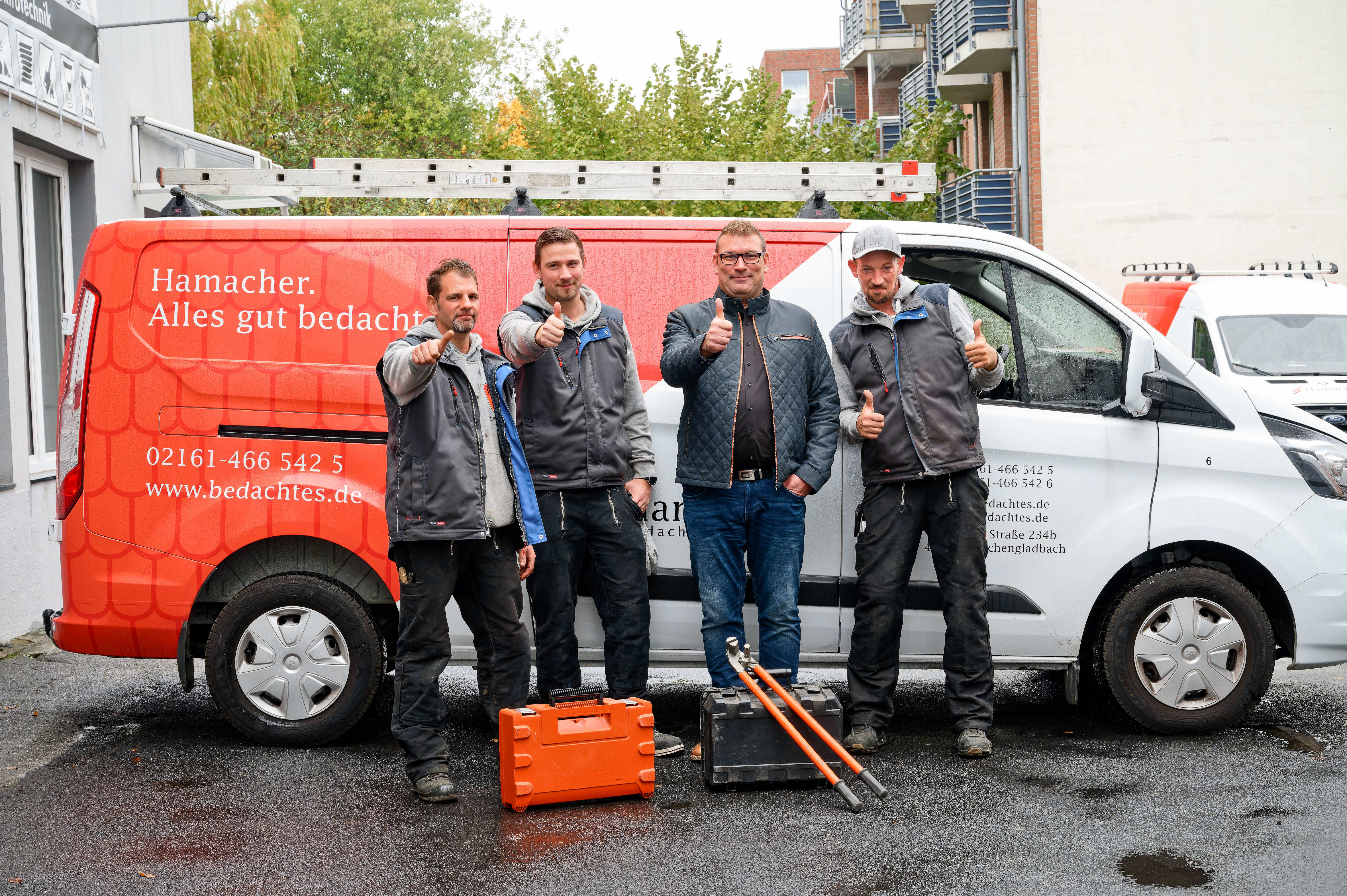 Das Hamacher-Team vor den Firmenfahrzeugen
